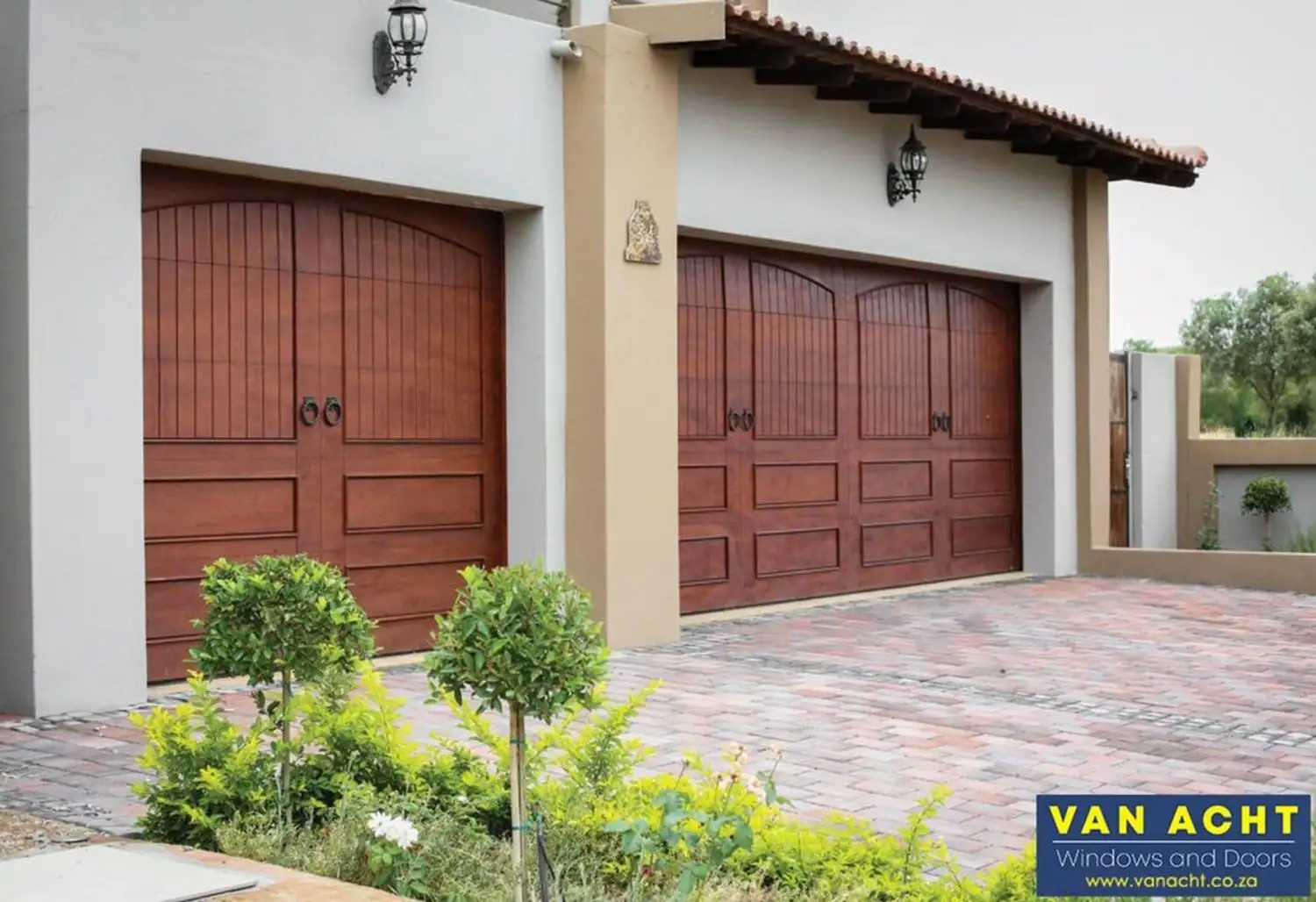 van acht wooden garage doors arched panel marine ply spanish style Van Acht wooden garage doors in marine ply with arched panel design and warm stain on a Spanish-style South African home
