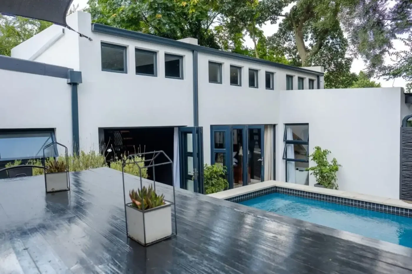 van acht aluminium folding doors awning windows pool entertainment area Van Acht aluminium folding doors and awning windows in charcoal on a modern two-storey home with pool and entertainment deck