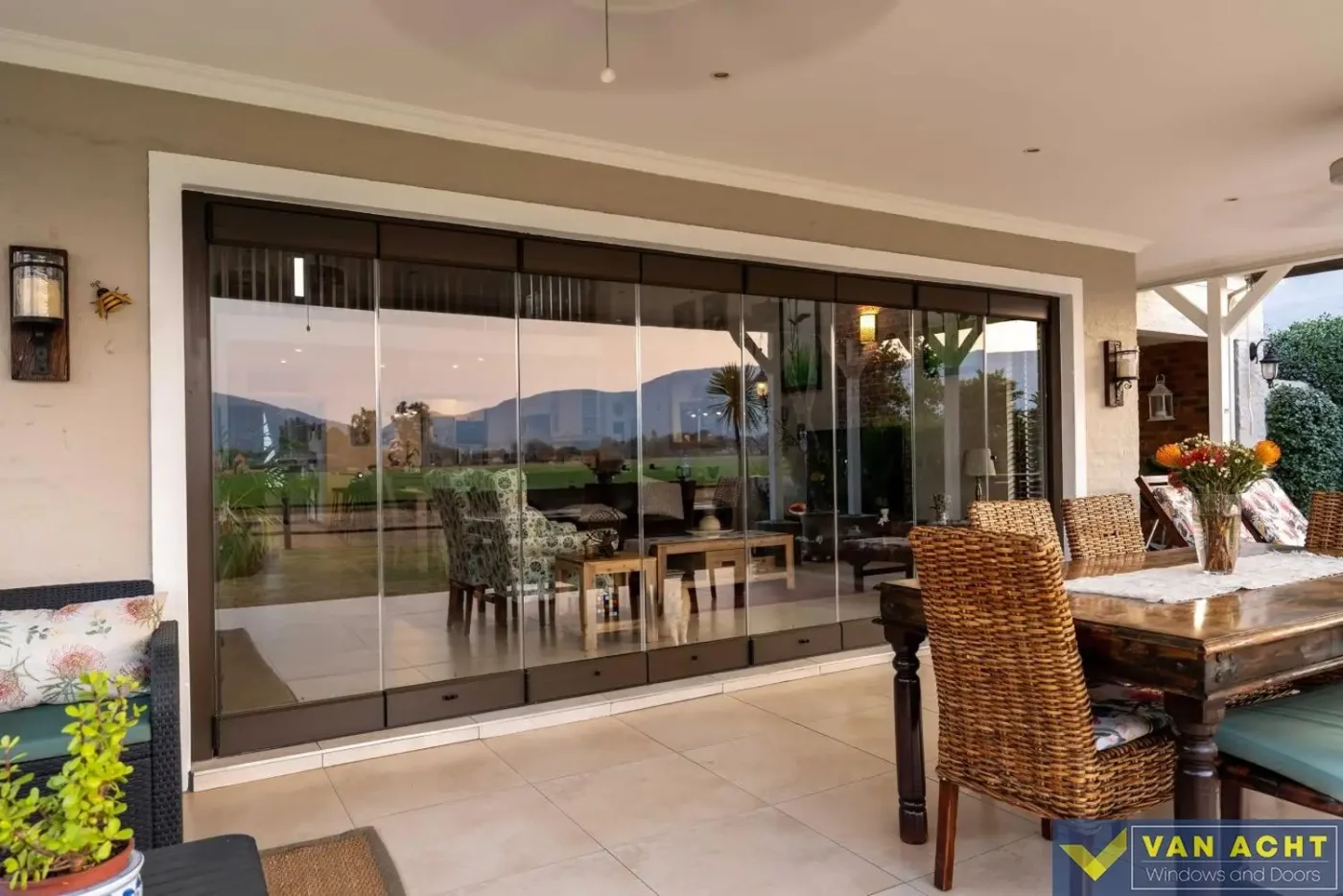 Aluminium stacking door open between a living area and a covered patio dining space